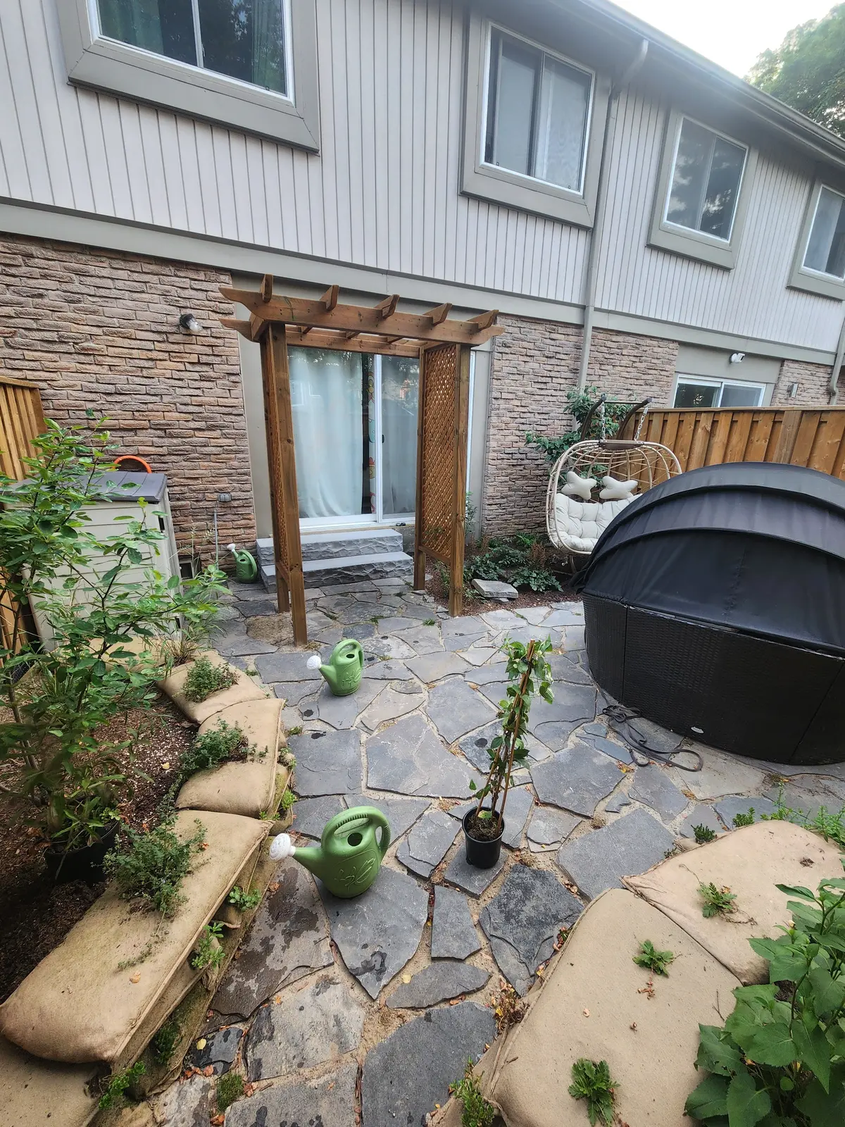 Cedar pergola over flagstone patio with outdoor seating