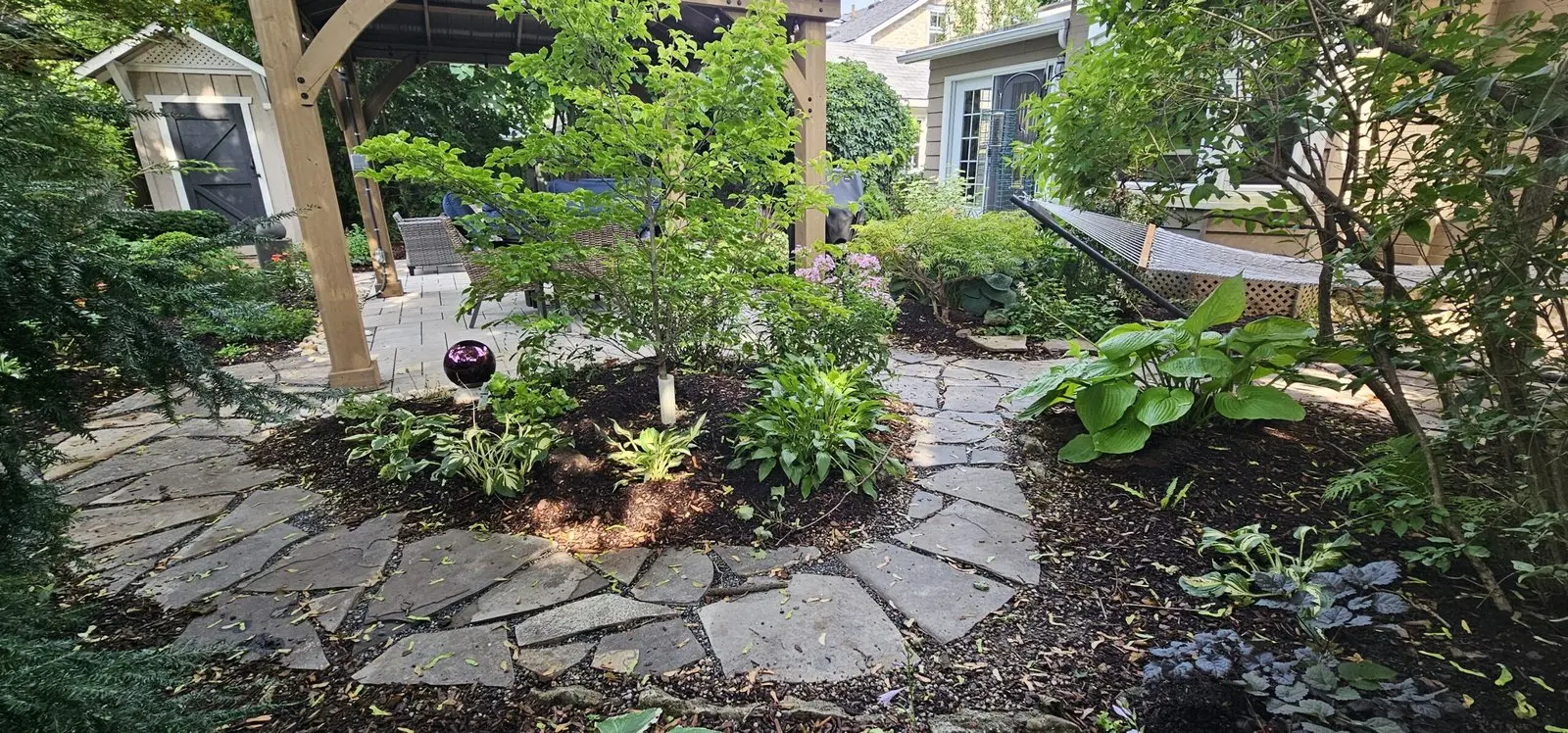 Flagstone patio with shade garden under pergola