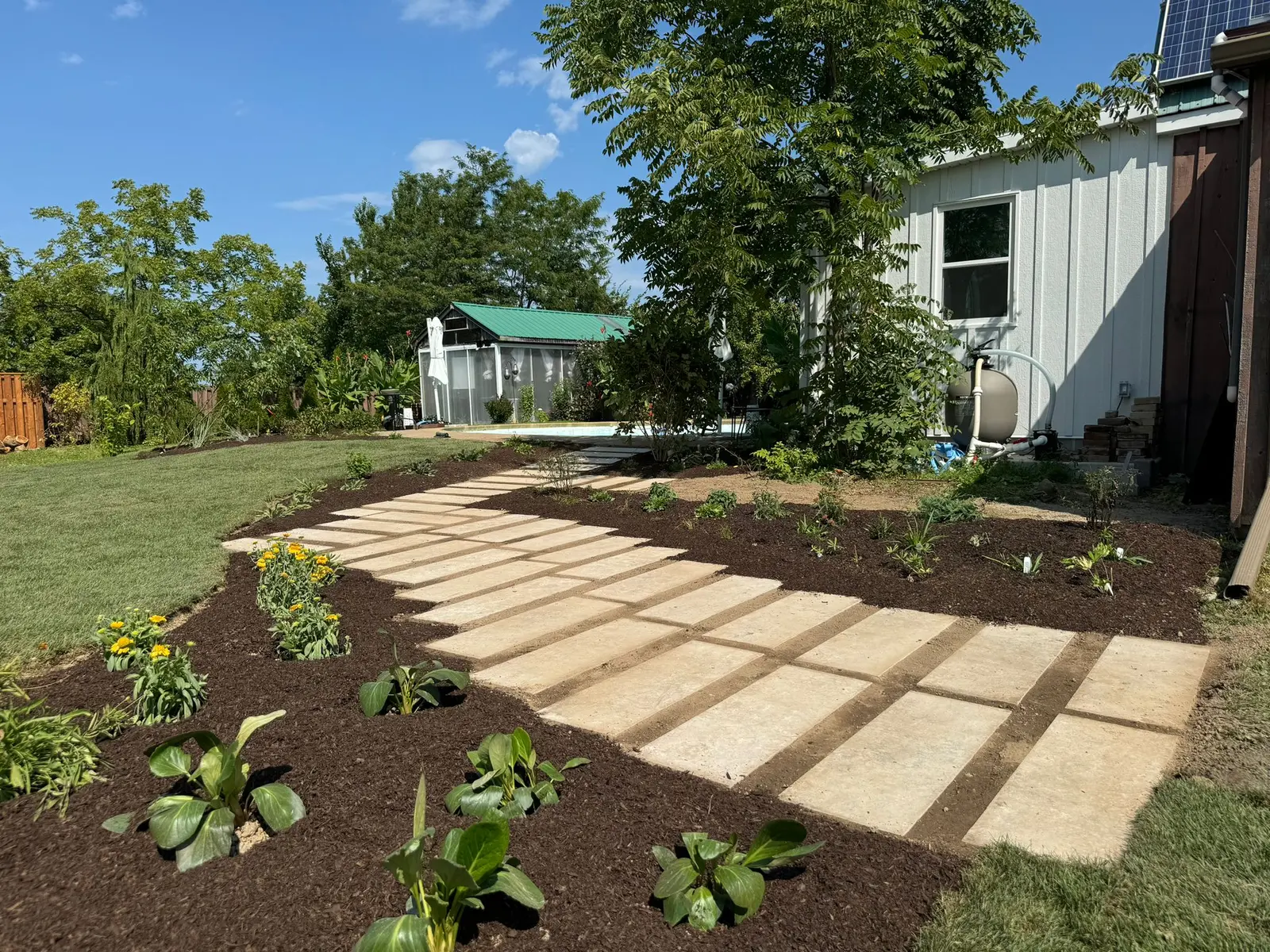 Natural stone slab walkway with fresh mulch garden beds