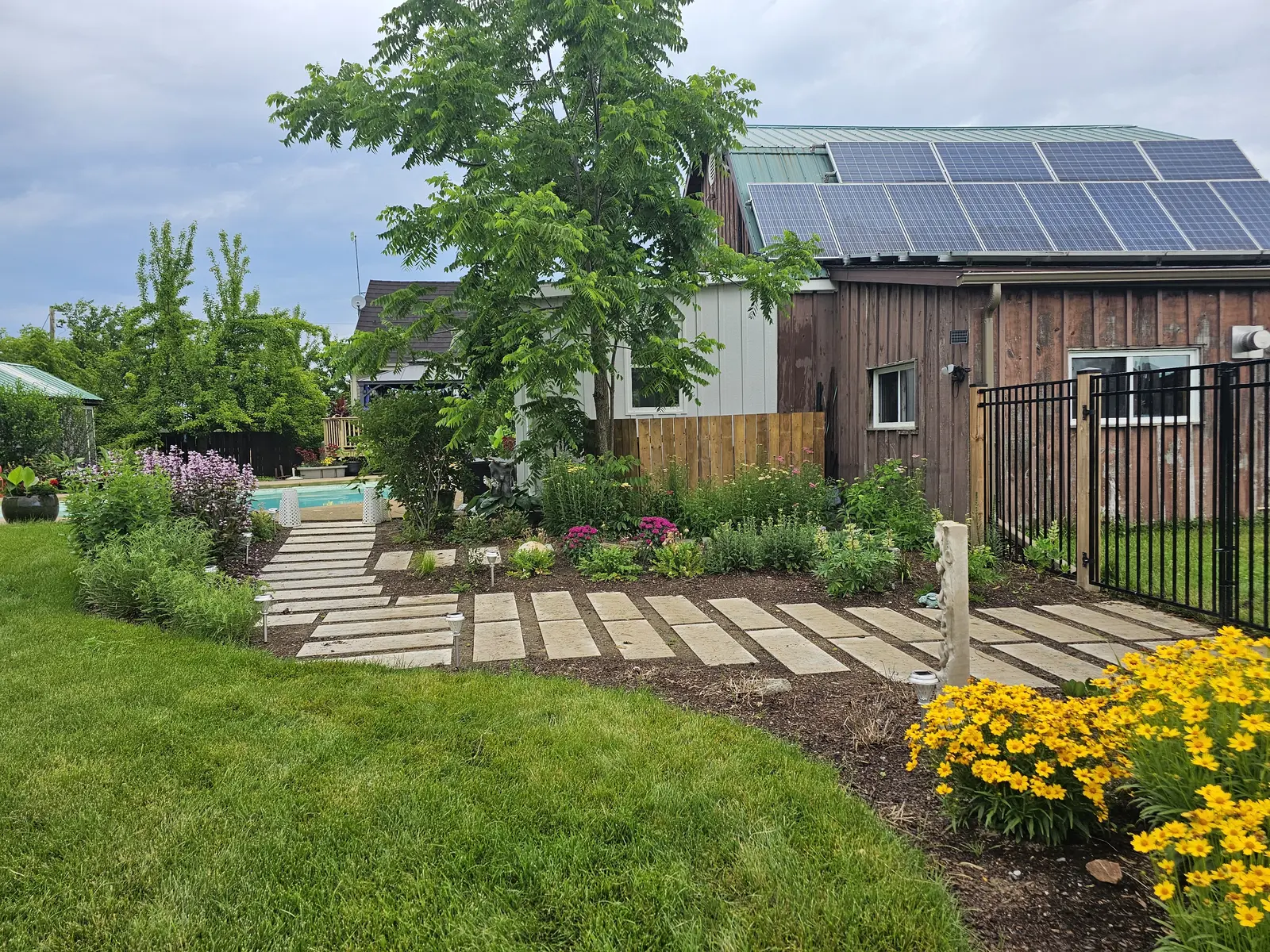 Natural stone slab walkway with perennial beds & pool gate