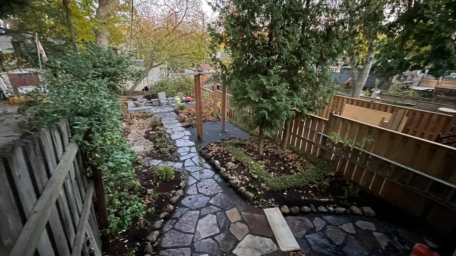 Flagstone walkway through autumn garden with arbor gate