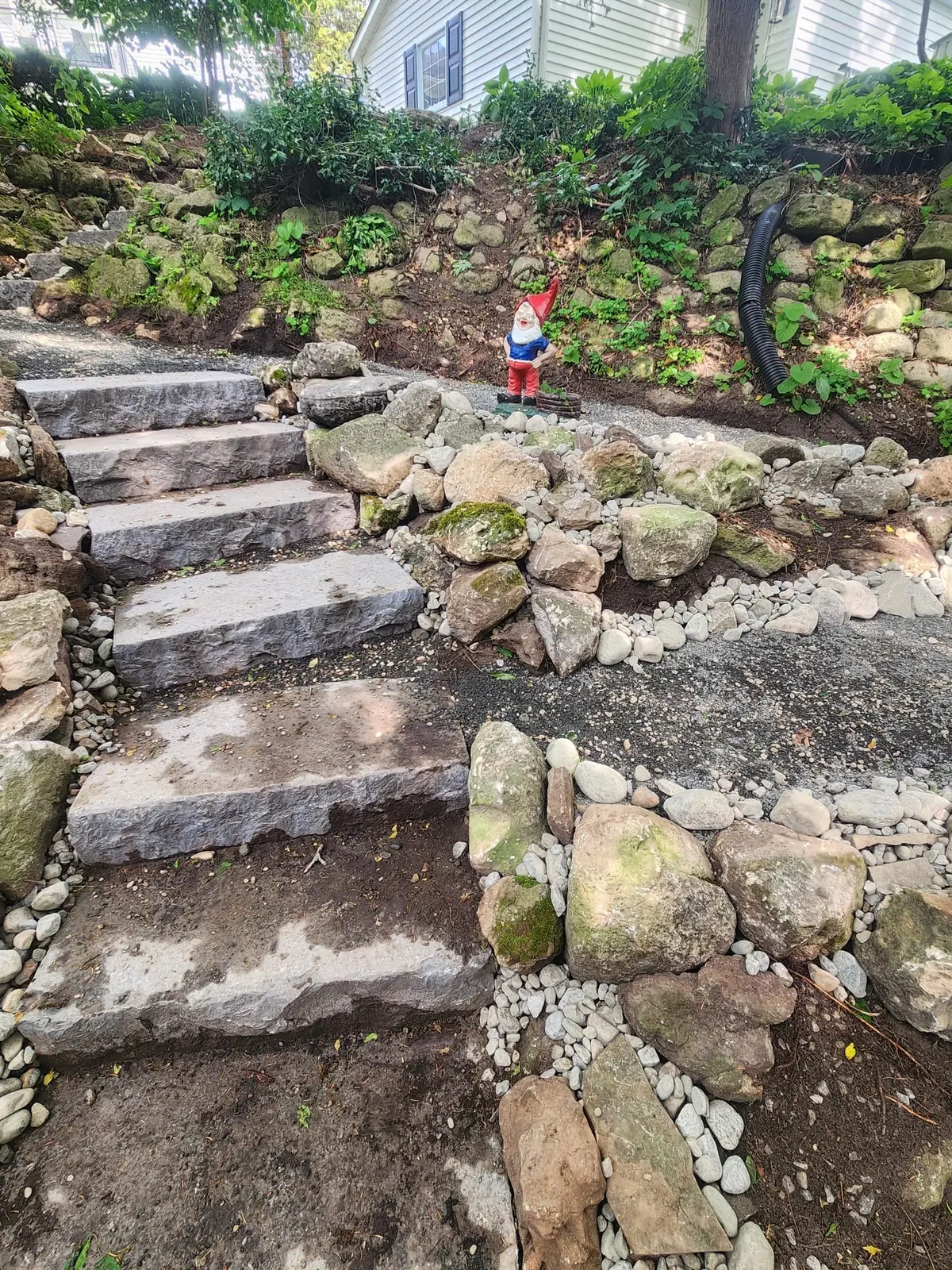 Natural stone steps with boulder retaining wall on hillside