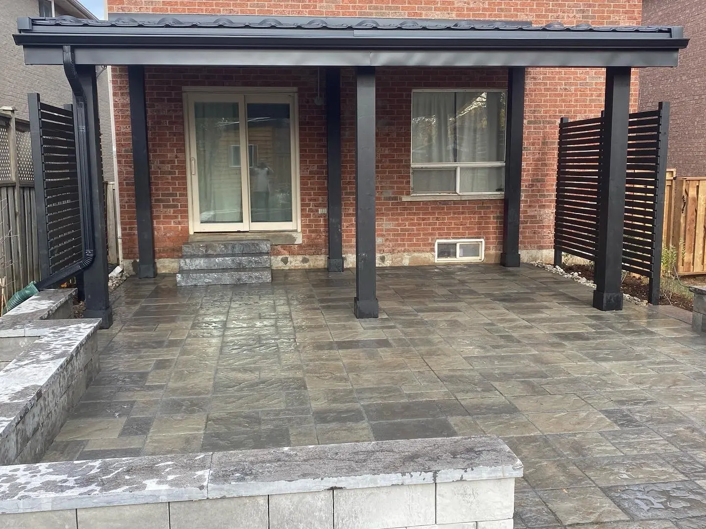 Covered patio with interlocking stone pavers & privacy screens