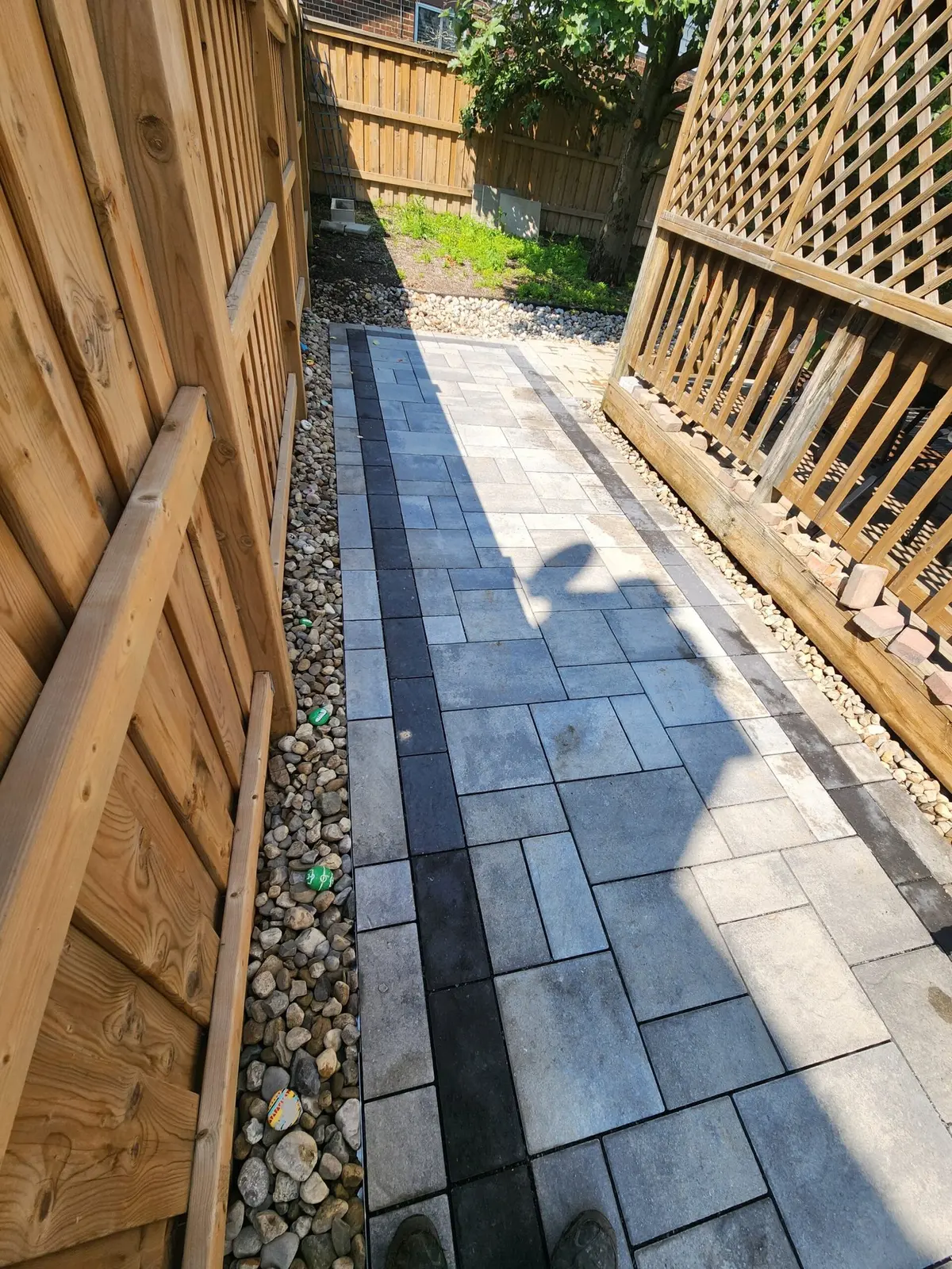 Interlocking paver walkway with dark border & river rock edging