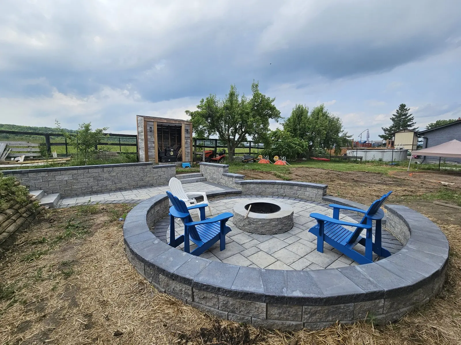 Circular fire pit with Adirondack chairs & paver seat wall