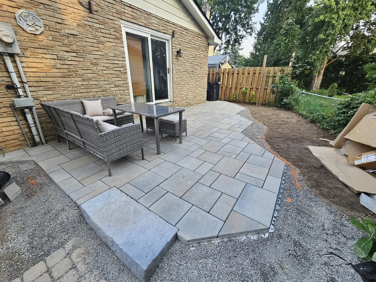 Backyard paver patio with outdoor furniture & step-up