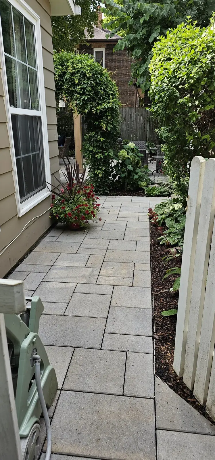Interlocking stone side entrance walkway with garden beds