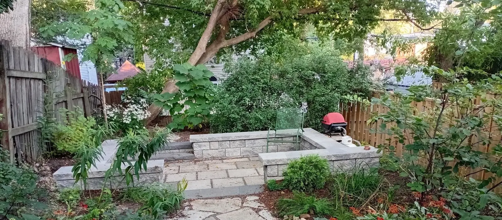 Small backyard paver patio with raised garden bed