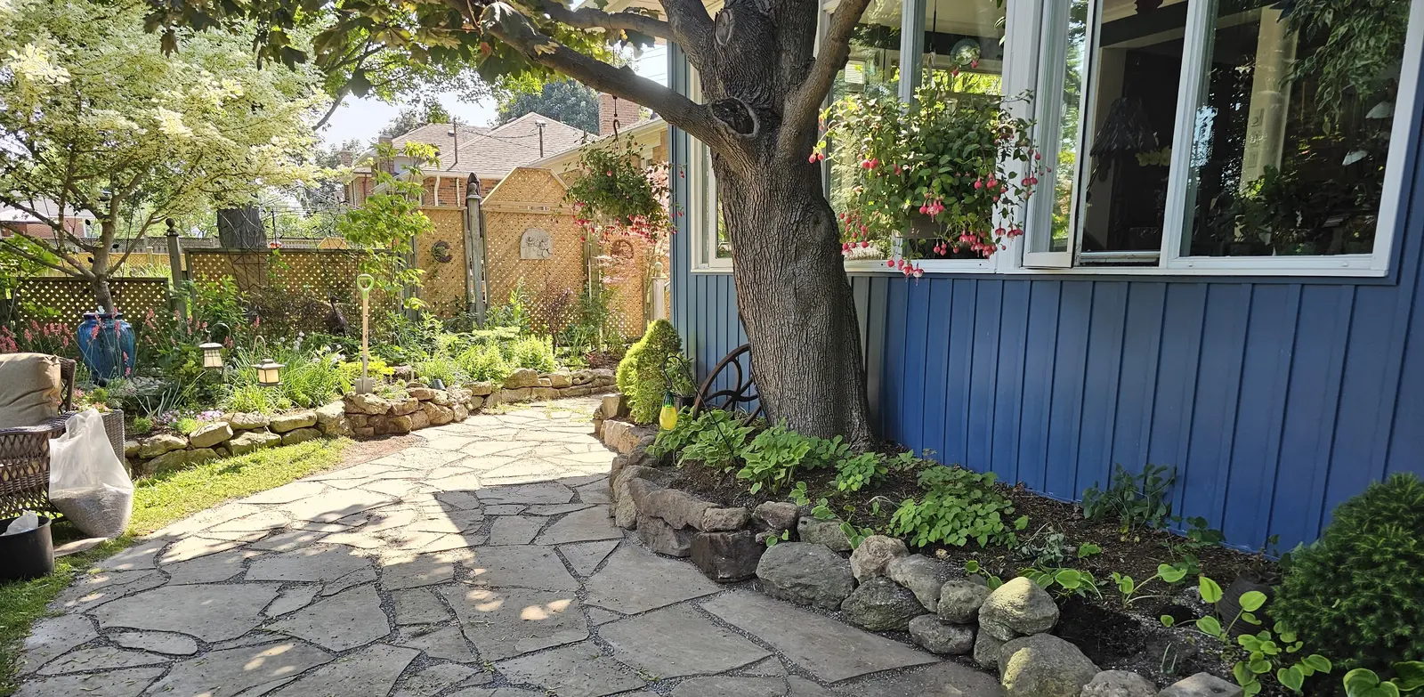 Cottage-style flagstone pathway with native plantings under mature tree