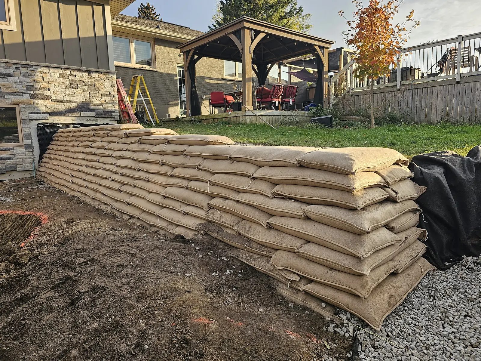 EnviroLok living wall installation in progress with stacked bags along backyard slope