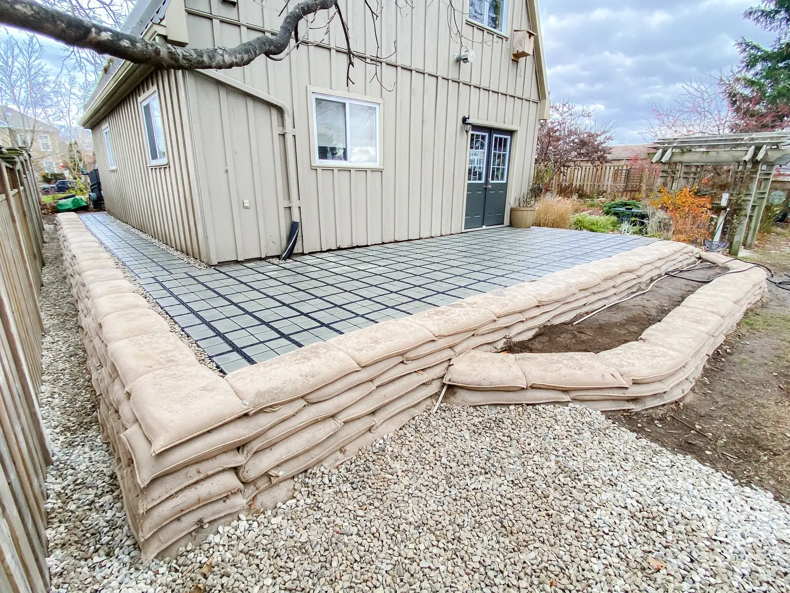 EnviroLok living wall bordering raised paver patio beside house