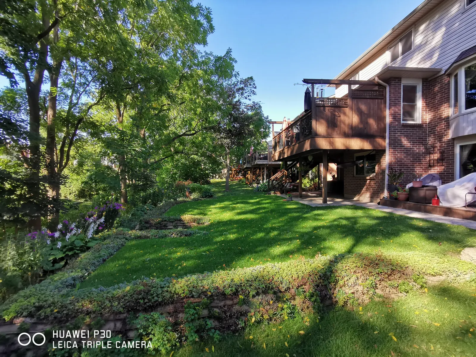 Wide view of mature EnviroLok wall with perennial garden beds on terraced backyard