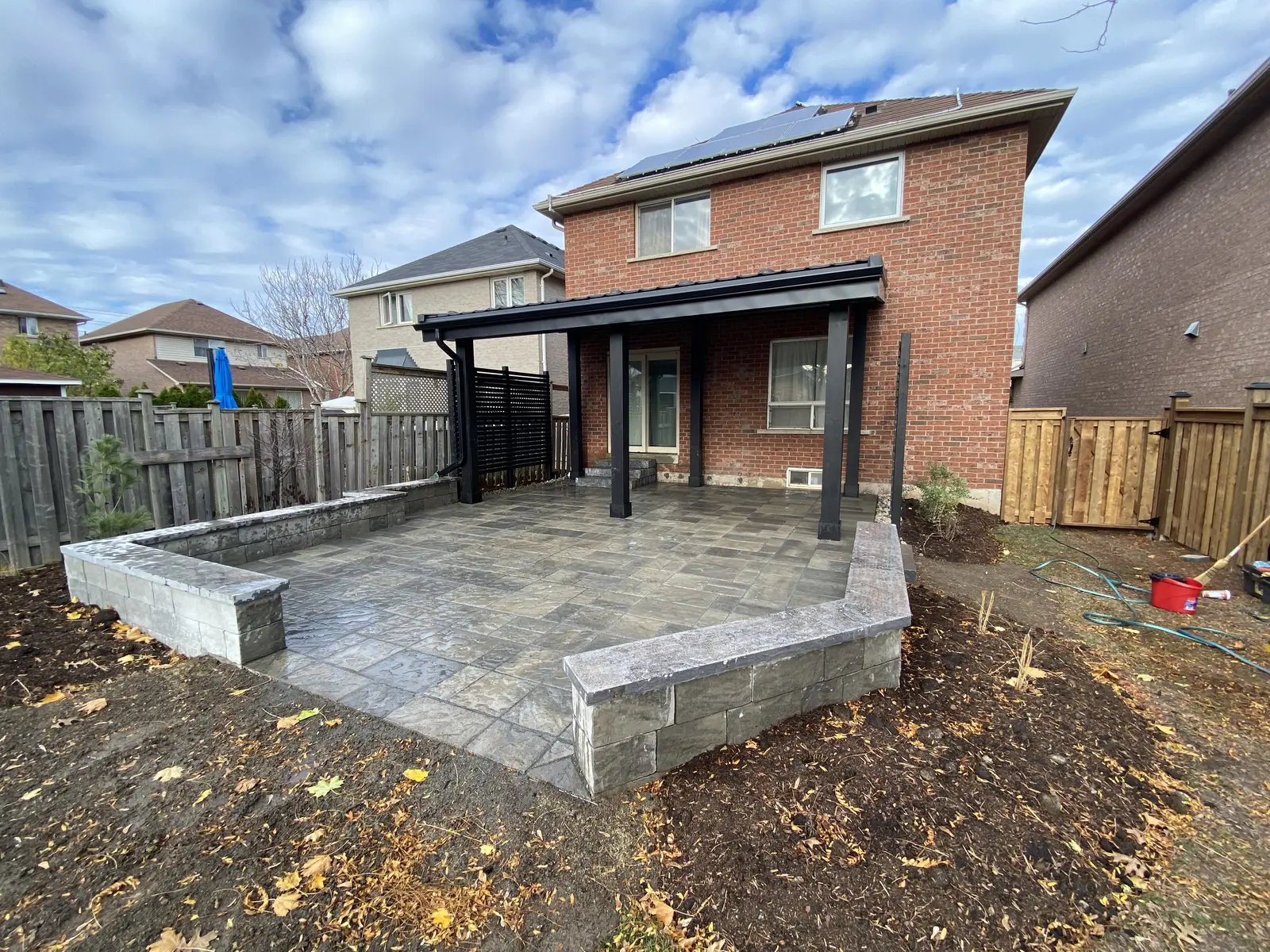 Raised paver patio with block retaining wall & pergola