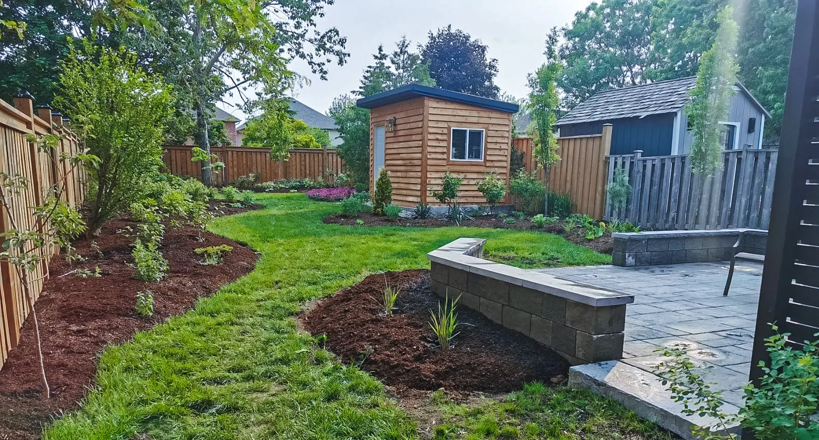 Block retaining wall patio with seat wall & garden shed