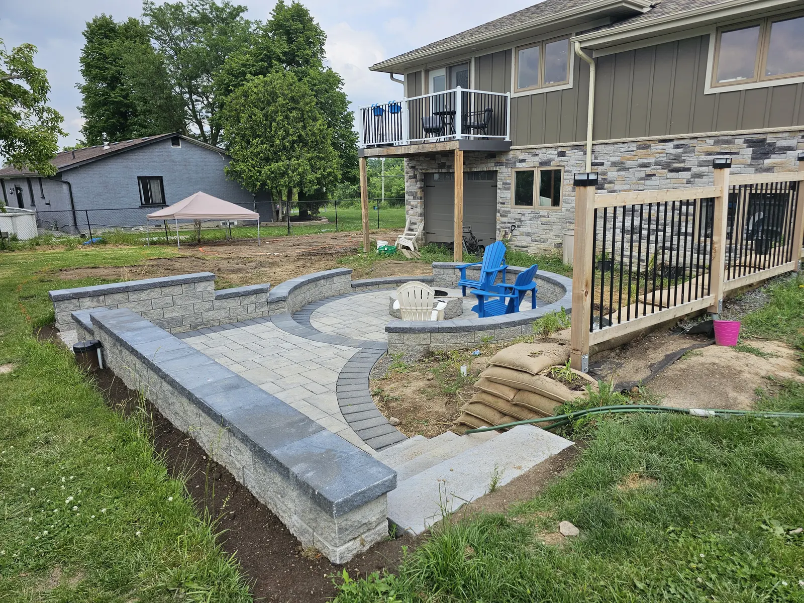 Curved block retaining wall with paver patio, seat wall & fire pit area