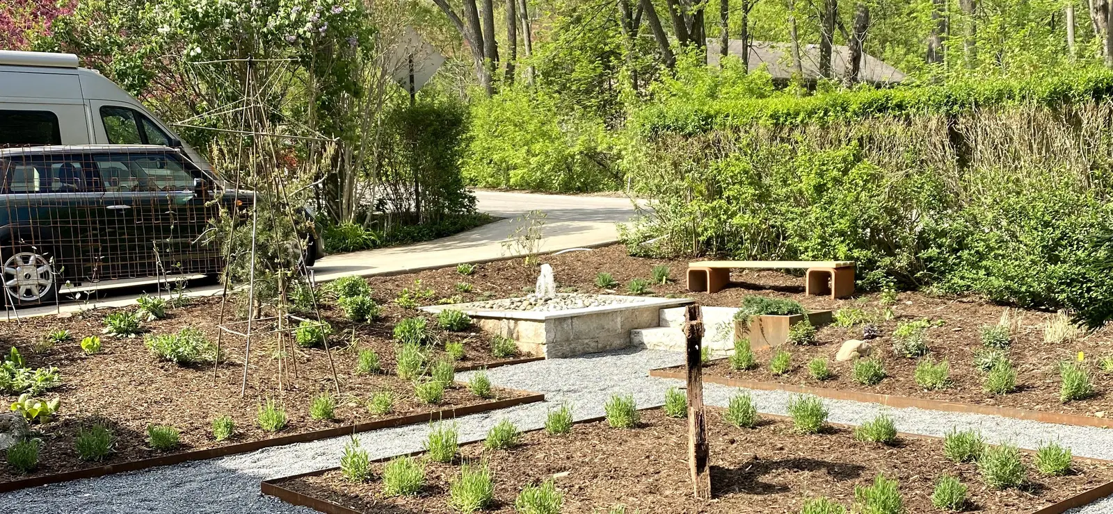 Pondless bubbler fountain with garden beds & stone benches