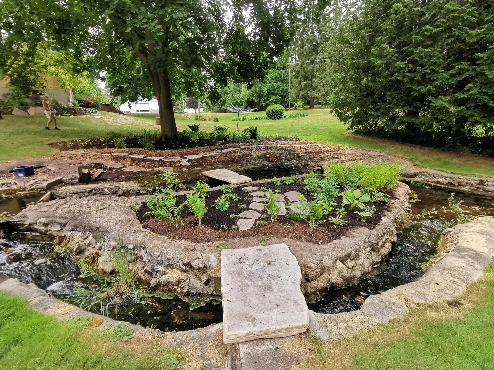Large stone pond with planted island & cascading water